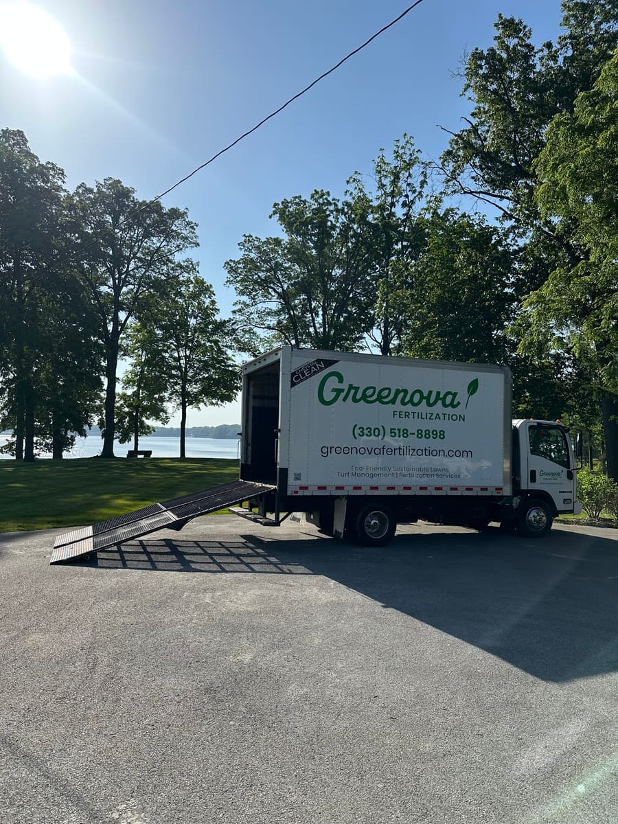 A Greenova Fertilization service truck parked at a large property